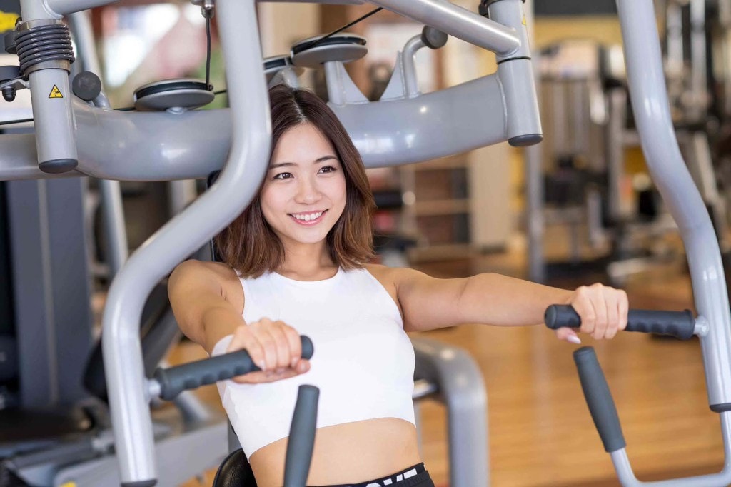 チェストプレスマシンでトレーニングする女性